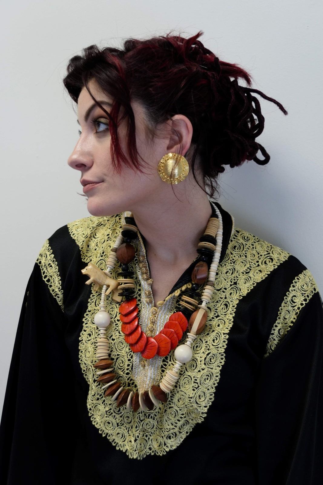 Brushed golden bold clip-on earrings with vintage design adorn a model's ear, showcasing the bright golden metal and brushed texture.