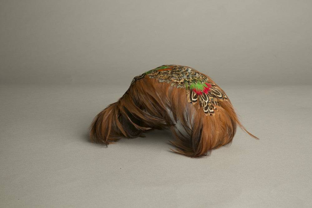 Vintage feathered toque hat in orange, green, and brown tones from the 1970s.
