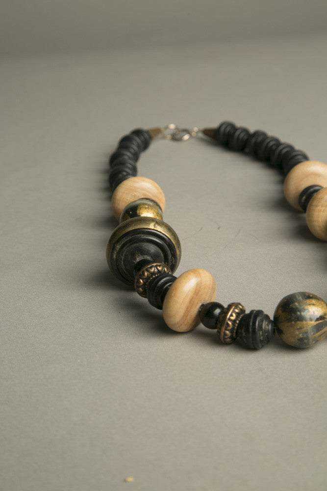 Ethnic tribal chic necklace with golden, black, wooden, and plastic beads.
