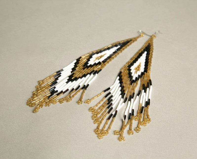 Handmade vintage shoulder duster earrings with translucent tubular beads in golden yellow, dark grey, and snow white.