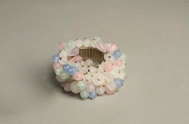 CHA CHA VINTAGE BRACELET featuring frosty beads in white, pink, blue, and green with metal wire links on an expandable golden bracelet.