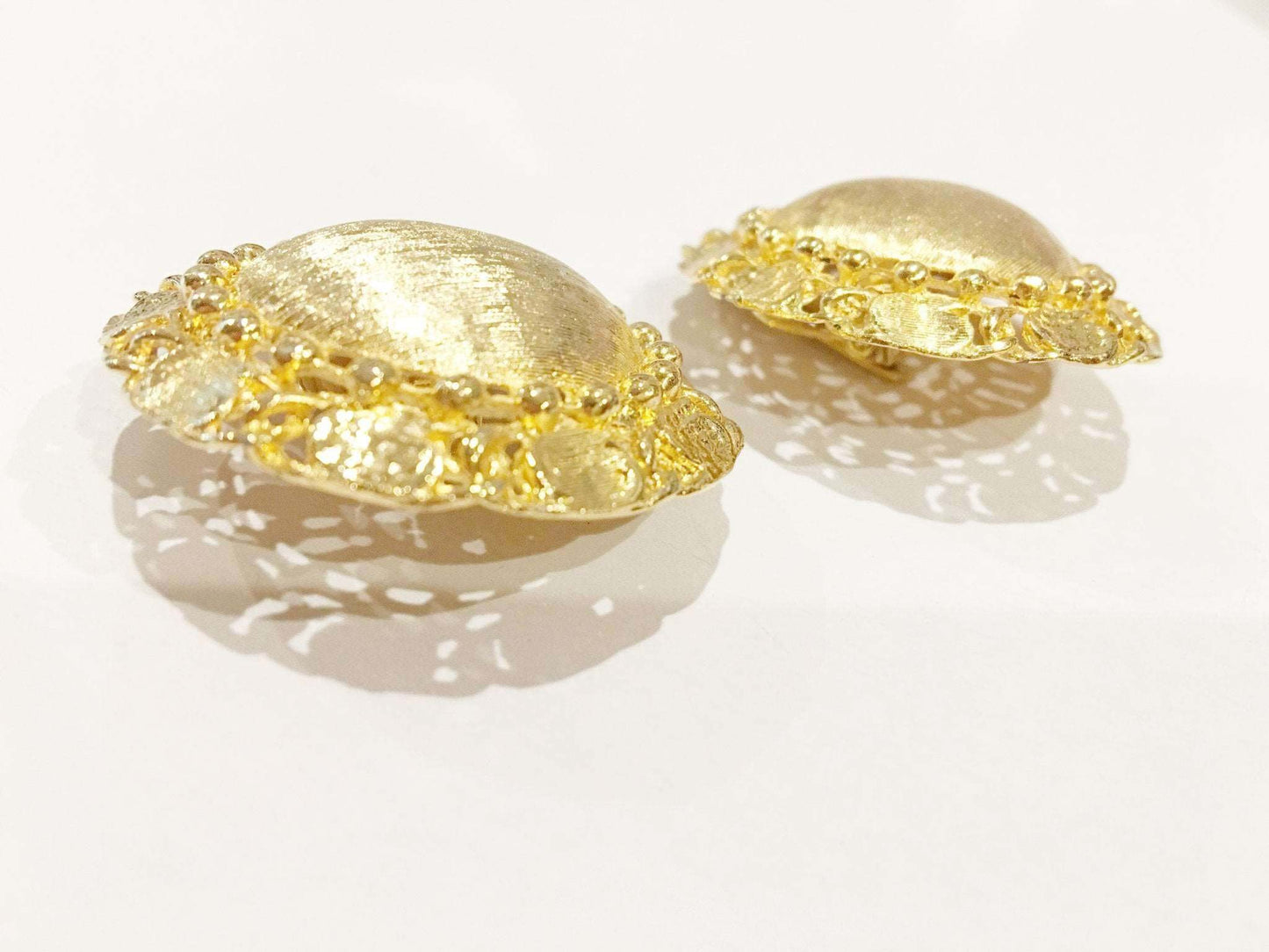 Brushed golden clip on earrings with textured surface, vintage 1980s-90s.