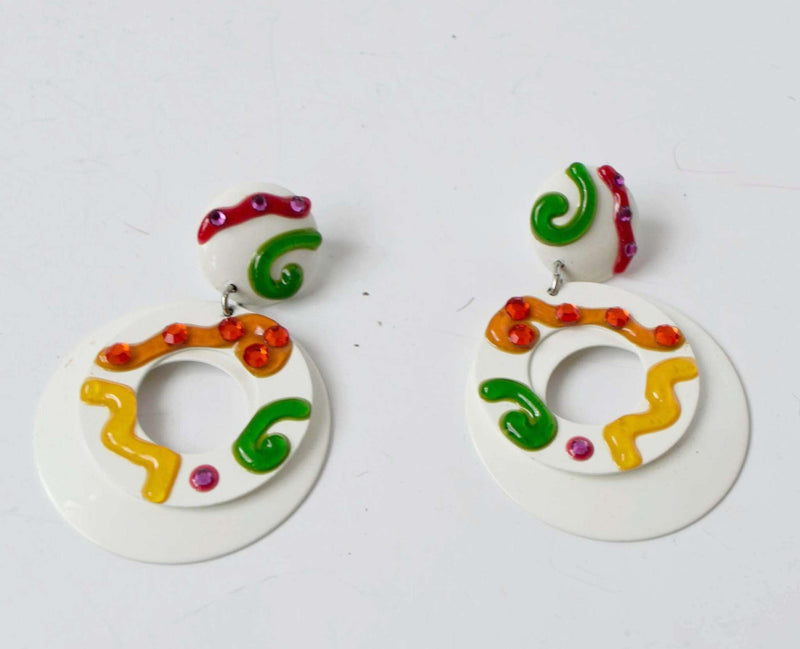 White colorful clip on earrings with pink, yellow, orange, and green swirls over white enamel tin, vintage 1960s-70s.