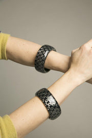 Set of 2 gray black resin bangles with psychedelic design and iridescent sparkles.