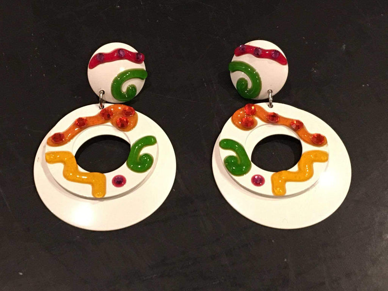 White colorful clip-on earrings with vintage pink, yellow, orange, and green swirls on white enameled tin, circa 1960s-70s.