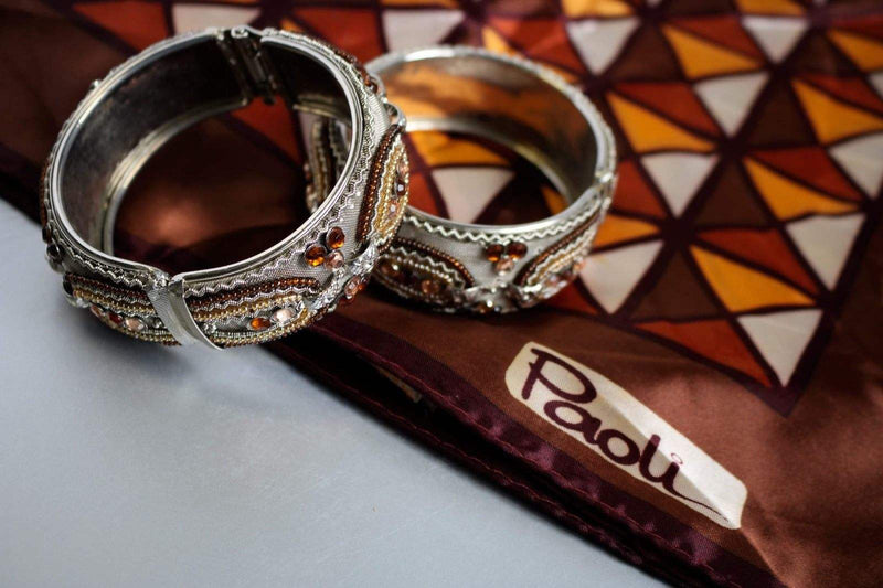 Set of 2 vintage hinged bangle bracelets with metallic beading in silver and gold tones.