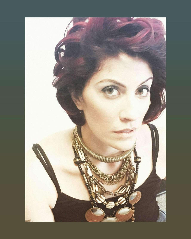 Ethnic beaded necklace with ivory, brown, silver, and golden beads on woman.