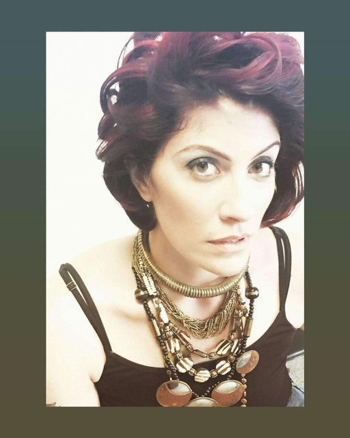 Ethnic beaded necklace with ivory, brown, silver, and golden beads on woman.