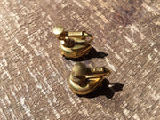 Miriam Haskell vintage red rhinestone earrings on wooden surface, showcasing luxury and elegance.