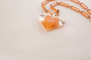 Vintage plastic jewelry necklace with clear heart pendant and chain links.