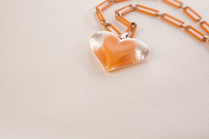 Vintage plastic jewelry necklace with clear heart pendant and chain links.